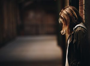 Depressed girl leaning against wall